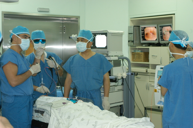 광역학 치료 원리를 설명하고 있는 의사들