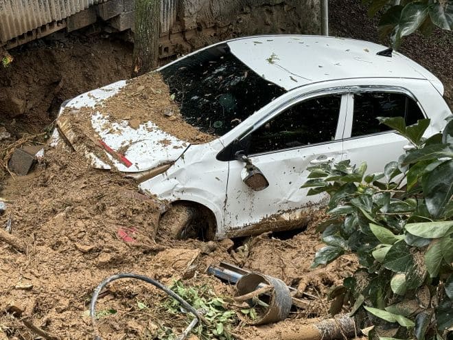 A vehicle is buried in mud from a torrential downpour.