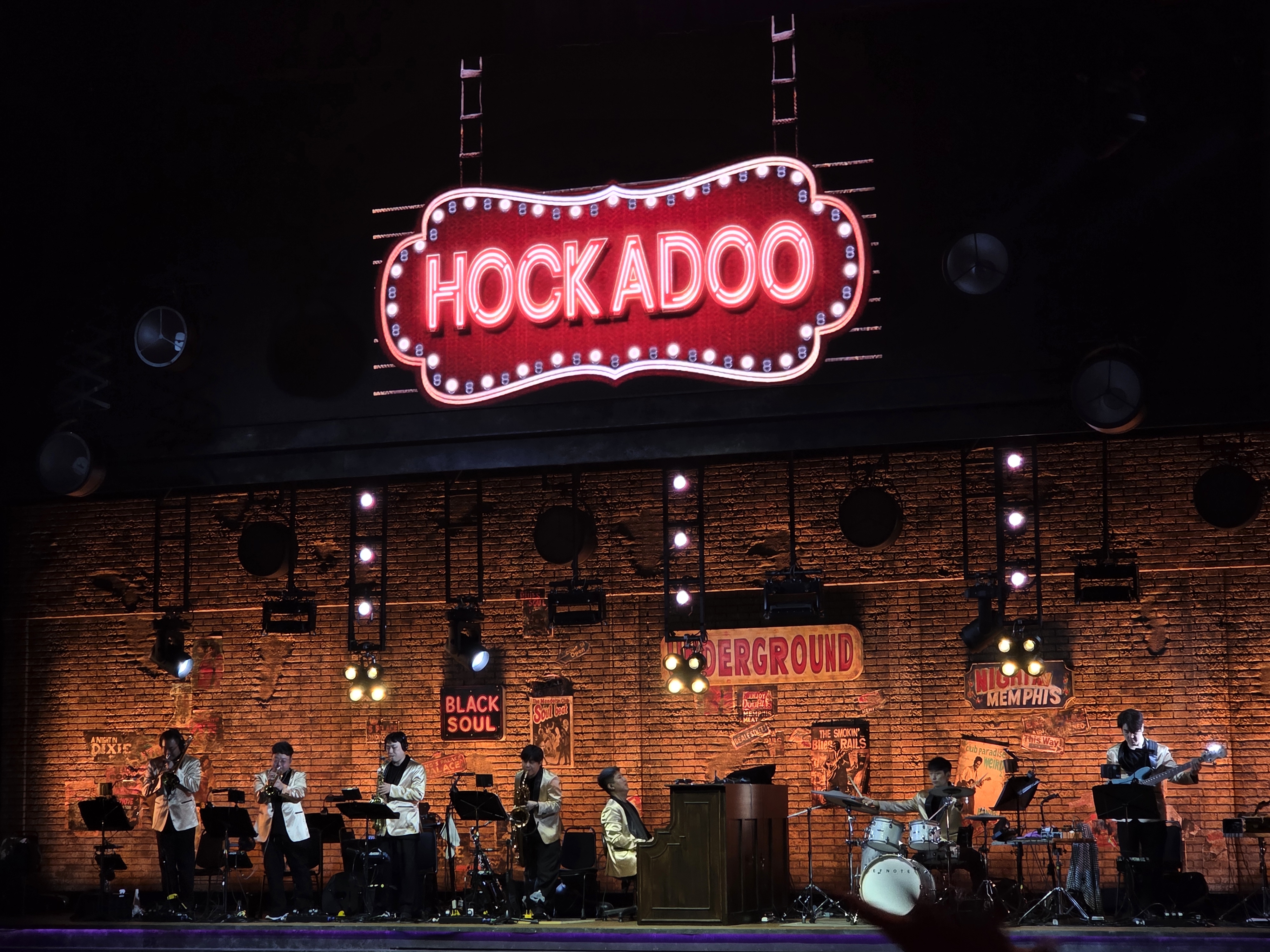 뮤지컬 멤피스 커튼콜 후 밴드 연주 장면, 무대 상단 HOCKADOO 네온사인과 연주자들의 실루엣