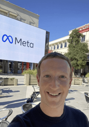 저커버그가 메타 사옥 앞에서 웃고 있는 장면