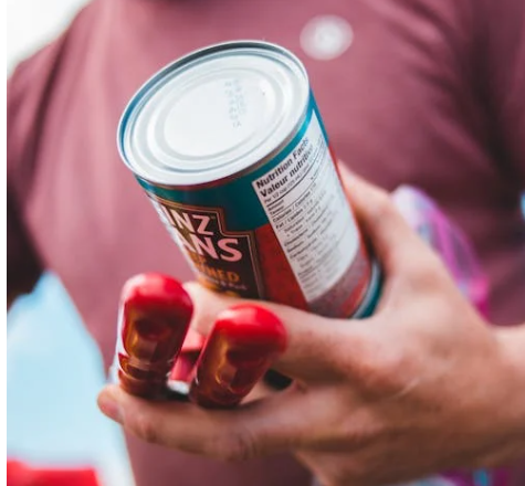 캔 식품의 영양 성분표를 확인하는 소비자의 손