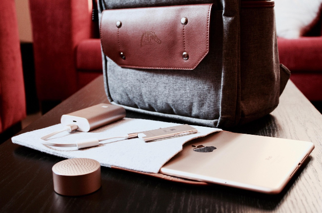 출근 준비를 위한 백팩과 태블릿, 보조 배터리, 휴대용 스피커가 정리된 모습