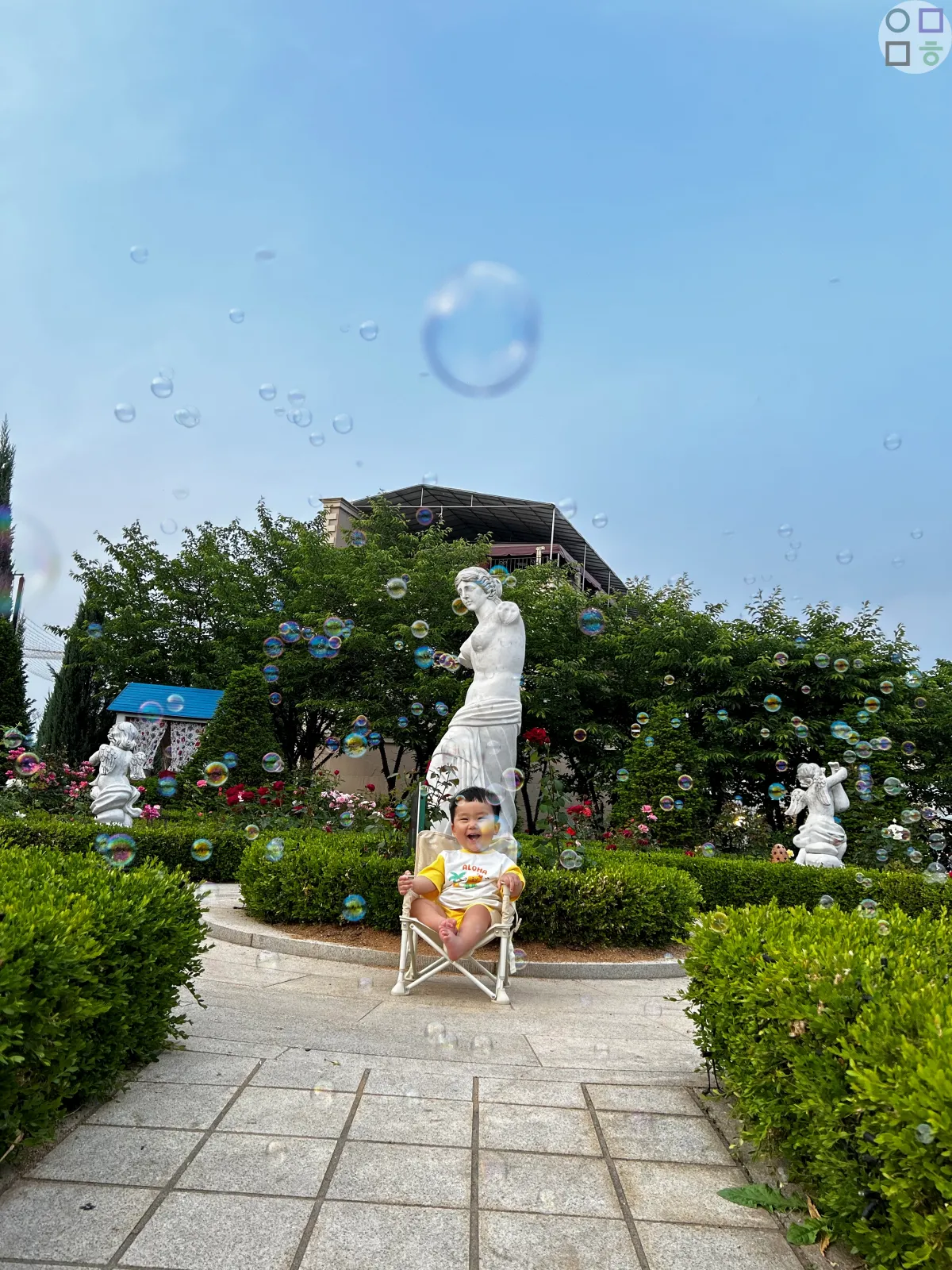 조각상-앞-아기-낮-사진-장미들