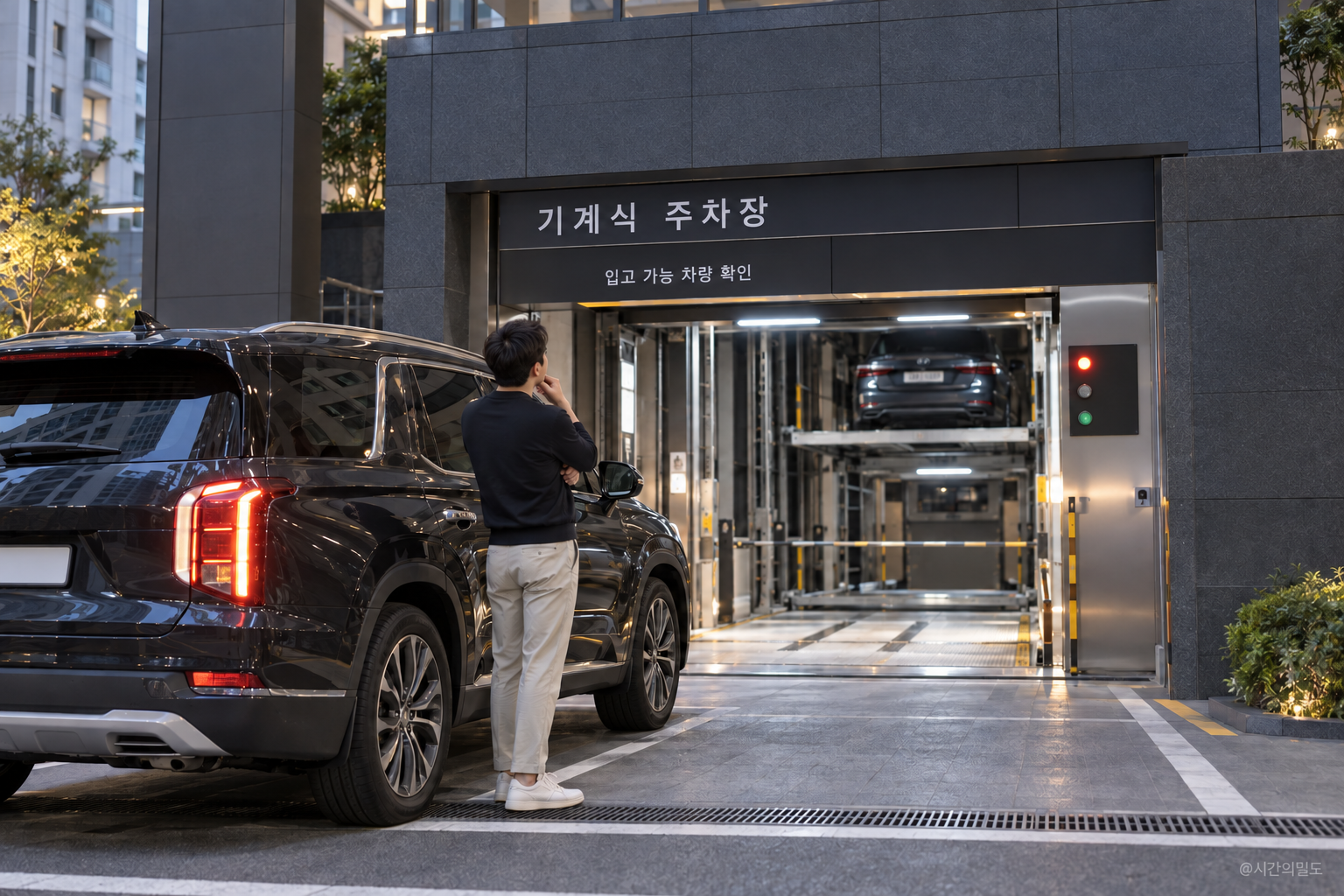 기계식 주차장 입구에서 차량 이용 조건을 살펴보는 사람