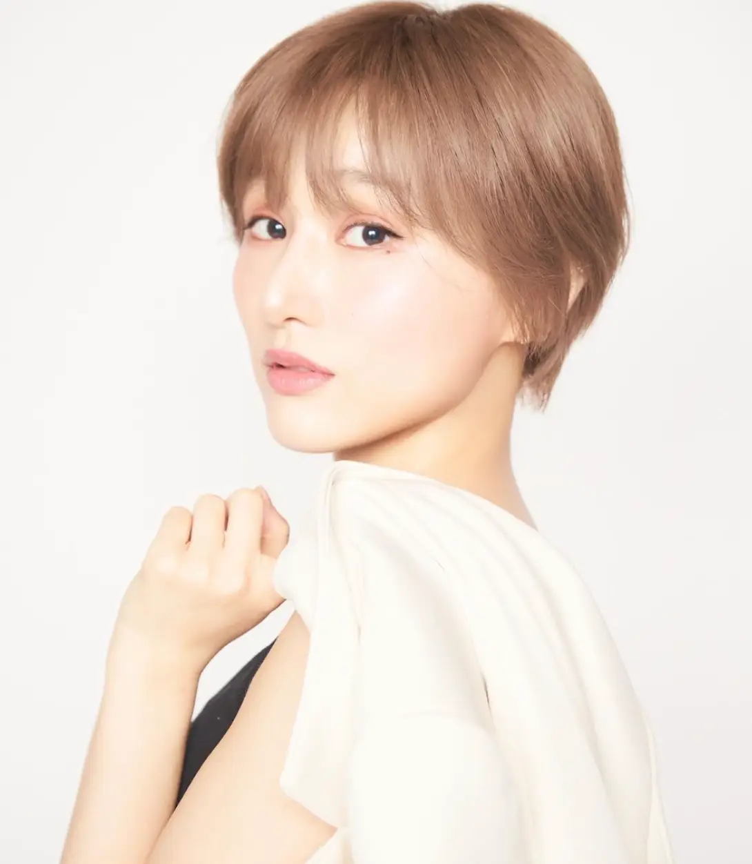 한일- 흰배경 흰색 블라우스를 입고 옆으로 선채 정면을 바라보는 마코토