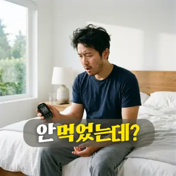 안 먹었는데?
이른 아침 햇살이 들어오는 깨끗한 침실에서 방금 일어난 30~40대 한국인 남성이 침대 끝에 걸터앉아, 한 손에 쥔 자가 혈당 측정기의 높은 수치를 내려다보며 도무지 이해할 수 없다는 듯 당황스럽고 억울한 표정을 짓고 있는 모습.