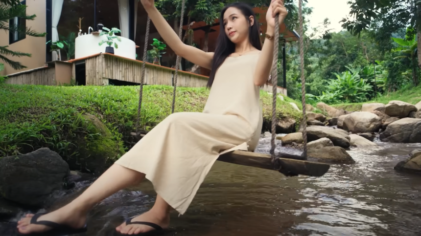 개천위에 설치된 그네를 타고 셀카를 찍는 남어이