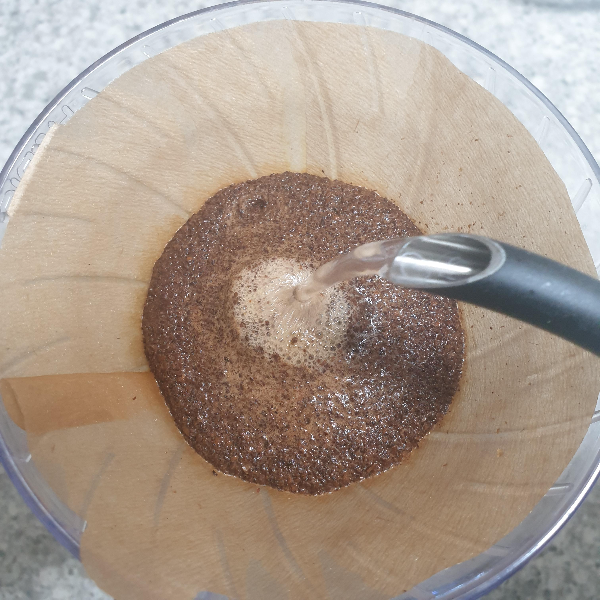 부불어오른 커피빵에 물을 붓는 모습. 가운데 거품이 일어난다.