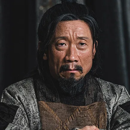 중년의 남자가 회색 옷에 긴머리를 묶고 수염이난 드라마 아라문의 검 열손 캐릭터