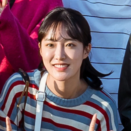 실외를 배경으로 알록달록한 줄무니 티셔츠에 검은 긴 머리를 뒤로 묶은 오늘도 사랑스럽개의 권리애 캐릭터