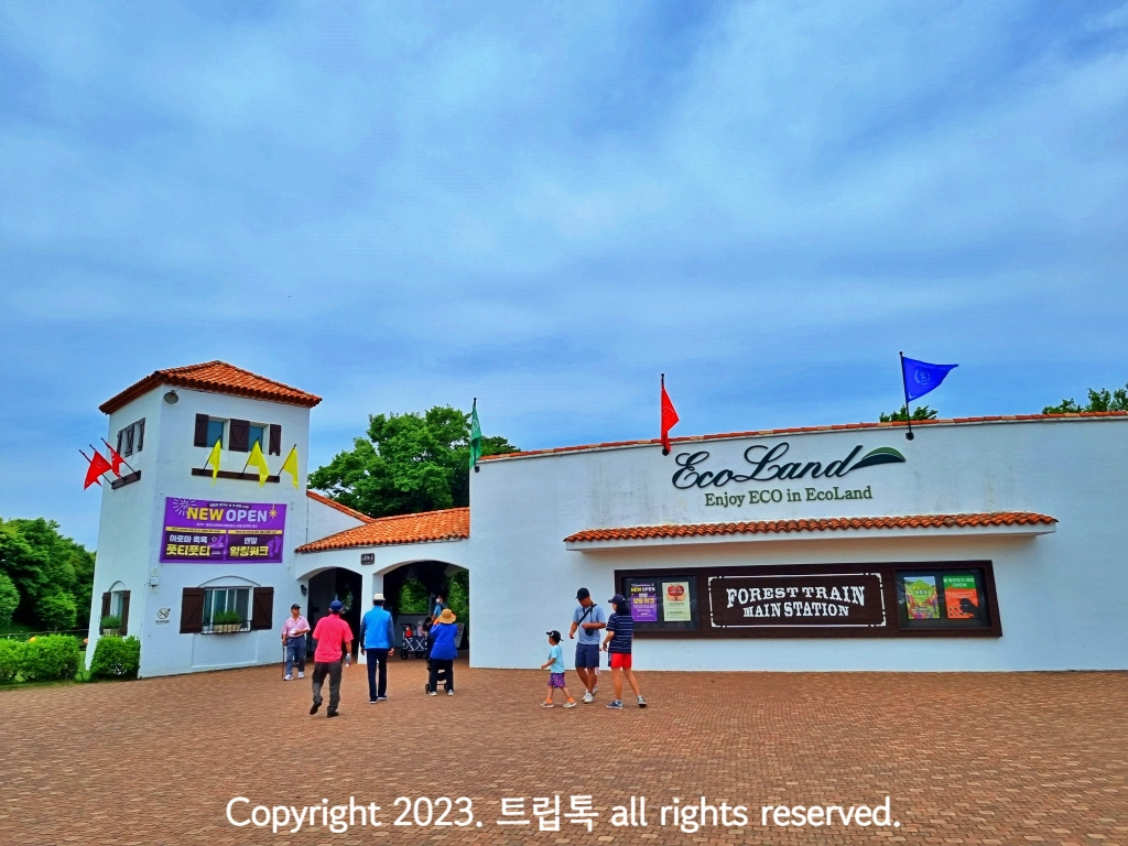 구름낀 하늘 아래 주황색 지붕의 하얀 건물이 보인다.