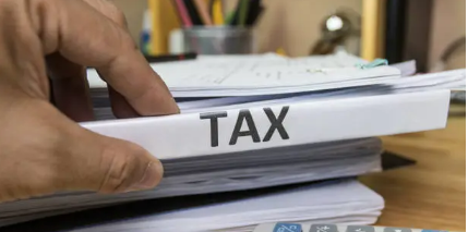 세금에 관한 서류와 고심하는 손의 모습