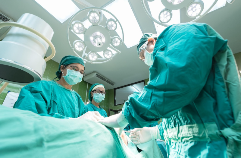 수술실에서 수술 준비 중인 의료진의 모습, 유도분만과 자연분만에 대한 의료적 선택 상황을 상징하는 이미지