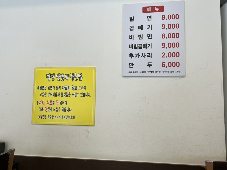 해운대밀면 메뉴판 사진, 밀면, 비빔밀면, 곱빼기 메뉴 표시
Photo of Haeundae Milmyeon menu board showing Milmyeon, Bibim Milmyeon, and Large Size