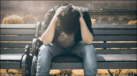 머리를 쥐고 고개를 수그린 남성