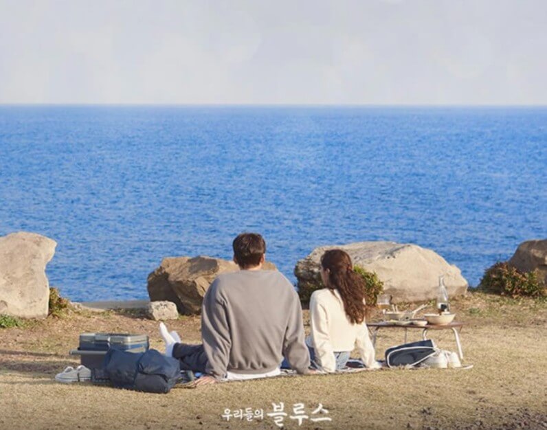 드라마 우리들의 블루스의 한 장면으로 김우빈과 한지민의 돗자리에 앉아 바다를 바라보는 뒷모습