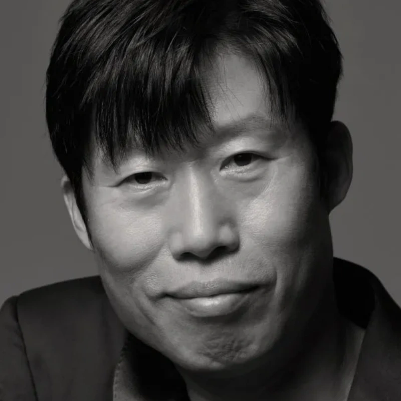 정장 자켓을 입고 미소를 띄고 있는 배우 유해진 흑백 프로필 사진