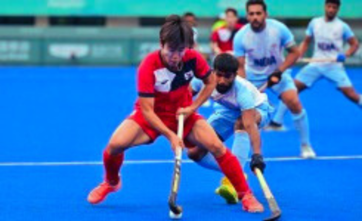 필드하키 경기 중 남자 선수가 스틱으로 공을 드리블하는 모습