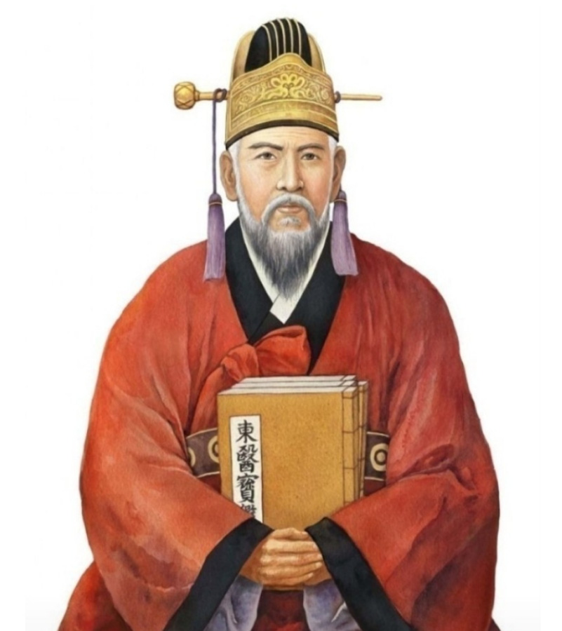 빨간색 의복과 머리에 금색의 의관을 쓴 허준이 동의보감을 가슴에 안고 있는 것을 그린 그림 사진