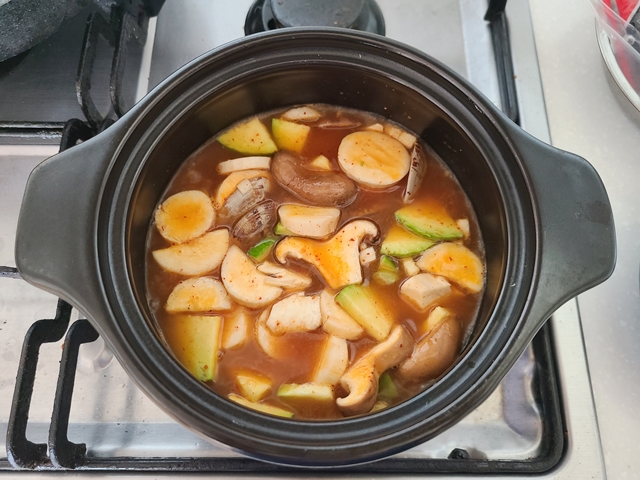 순두부찌개 양념장을 섞은 물이 끓어오르고 애호박, 버섯을 넣어준 모습