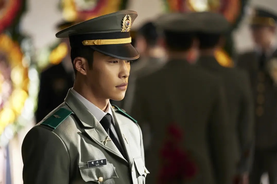 군복입은 남자가 아련한 눈빛으로 서있는 모습