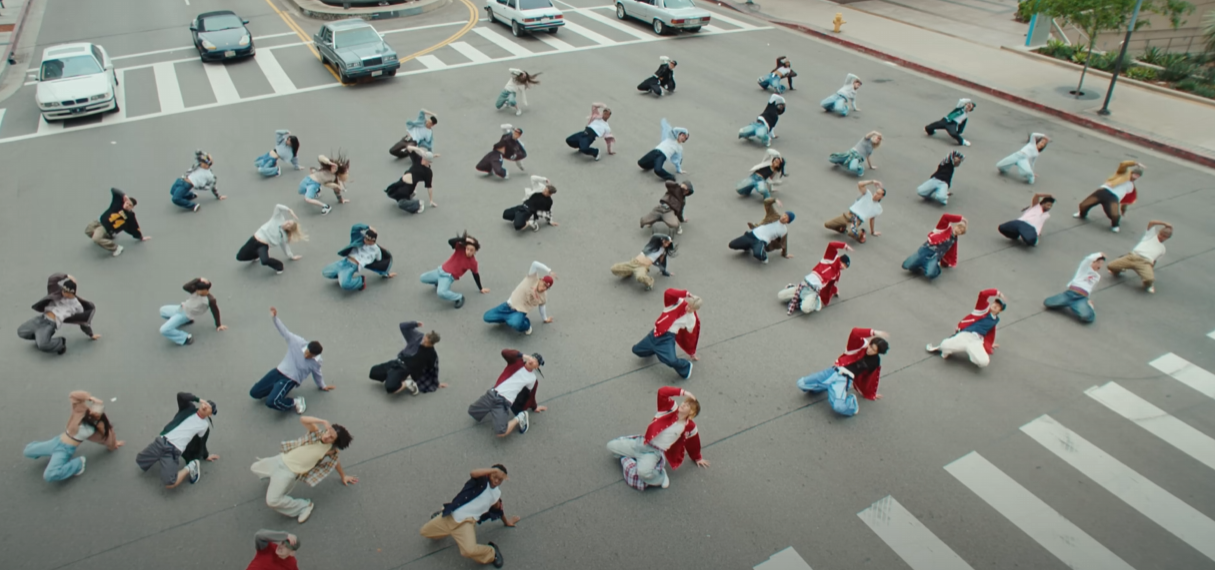 길거리에서 메가크루와 함께 춤을 추는 장면