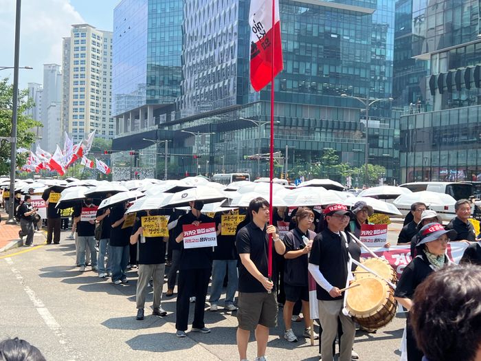 우산 쓴 카카오 노조 행진 - 카카오 노조가 '책임&middot;소통&middot;사과' 문구가 적힌 우산을 들고 거리 행진을 하고 있는 모습