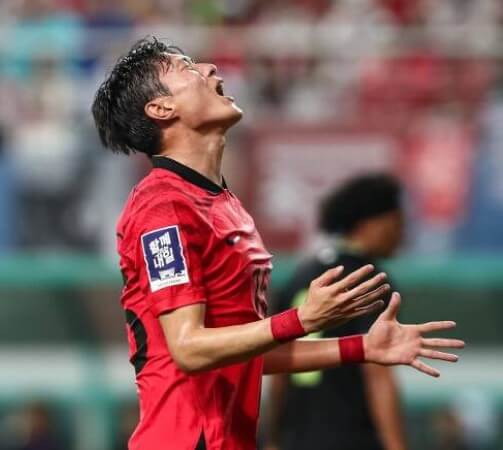 축구 선수 황의조가 경기 중 포효하는 모습의 사진