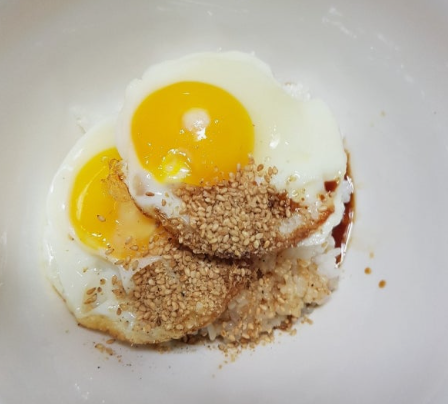 따끈한 밥 위에 계란후라이 두 개와 간장, 참기름, 깨소금을 뿌려준 간장계란밥.