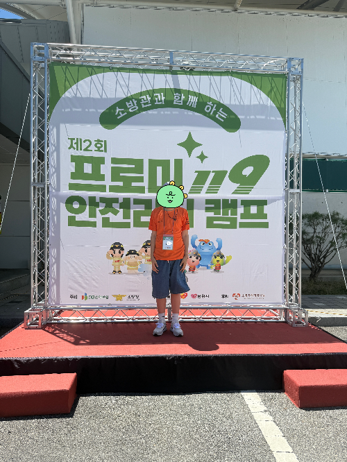 제2회 프로미 119 안전리더 캠프에 참가한 학생이 캠프티셔츠를 입고 기념사진을 찍고 있다