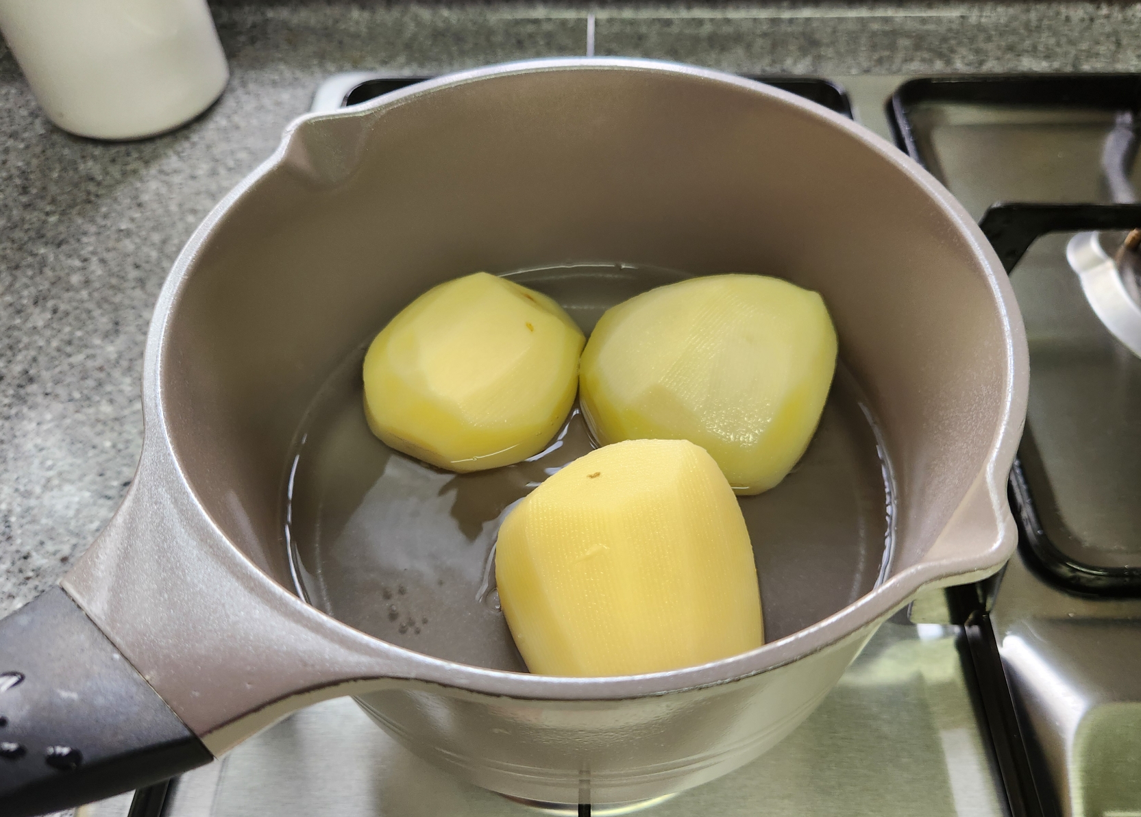 깎아놓은 감자를 물에 삶는 이미지