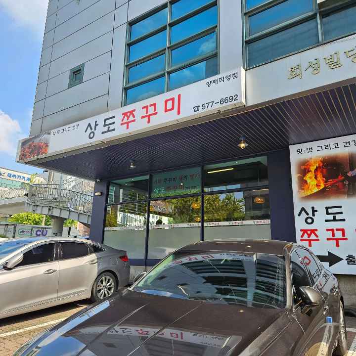상도쭈꾸미-간판이-있고-아래에-차들이-주차되어있다-cars-are-in-the-parking-lot.