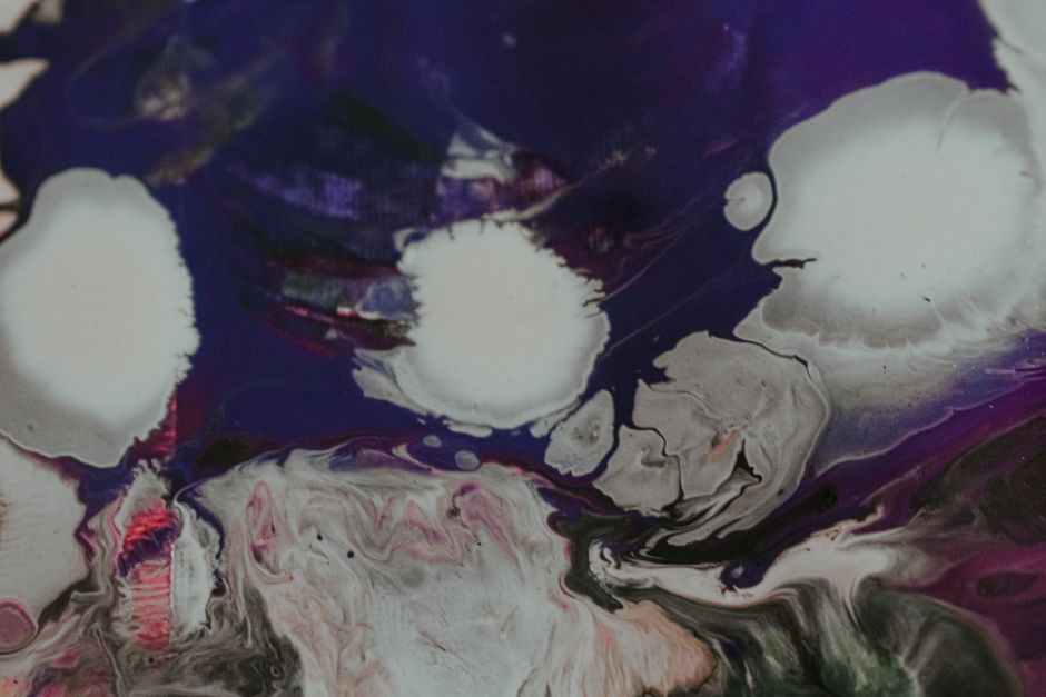Top view abstract mix of colorful dyes floating on surface and creating swirls as background
