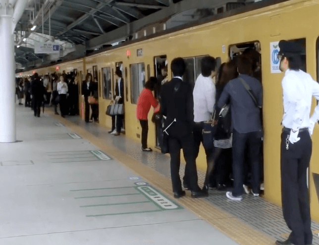 일본 러시아워에 열차에 타려는 승객들과 밀어 넣으려는 직원들