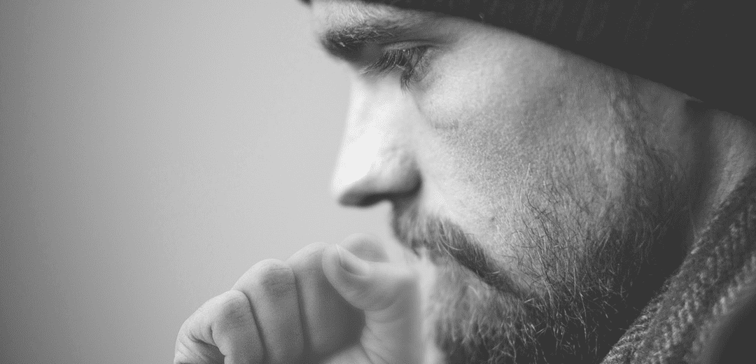 주먹으로 입을 가리고 기침하는 남성