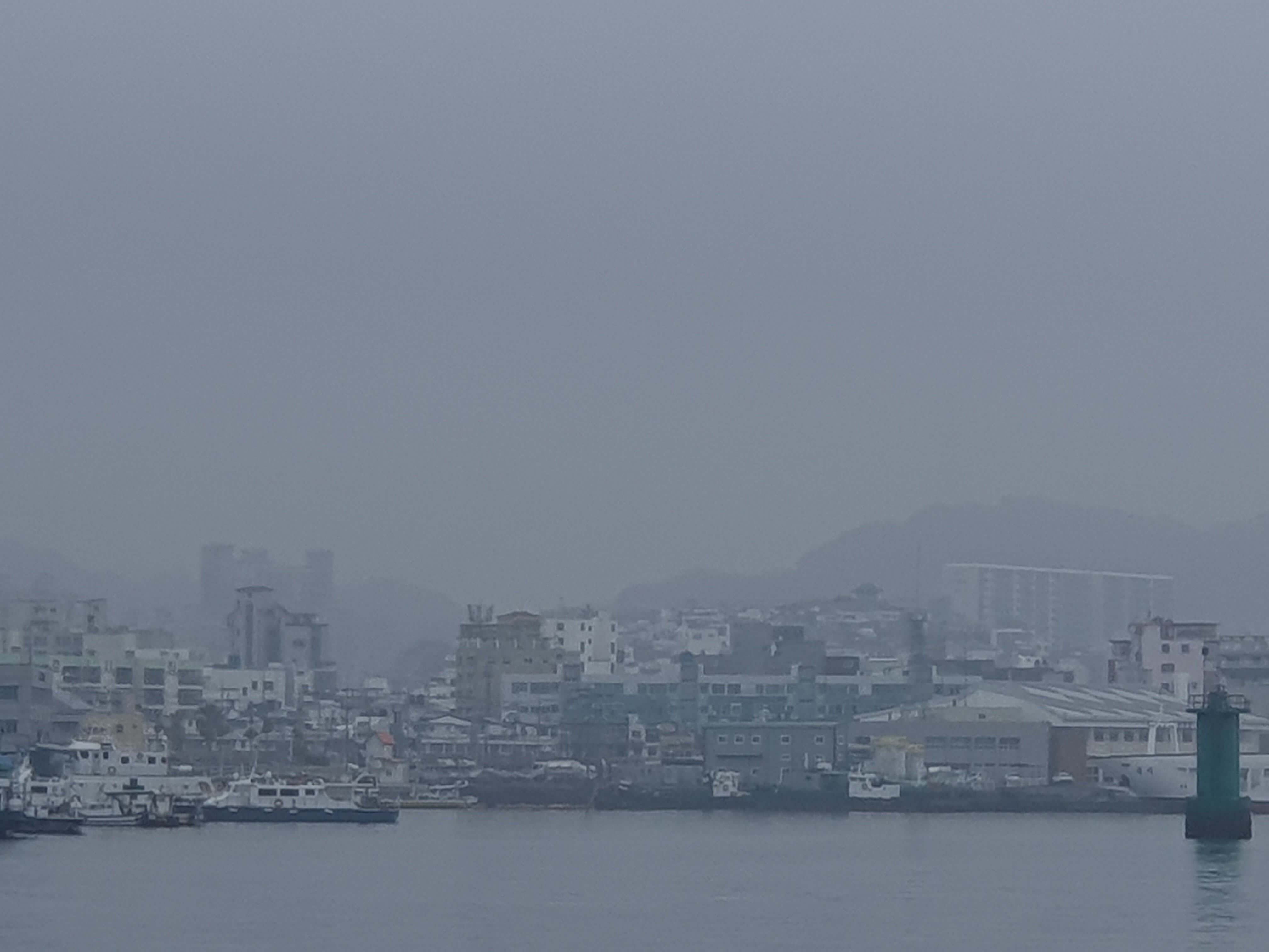 바닷가 미세먼지 가득 건물들 희미하게 보임