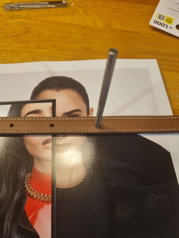 펀칭기로 가죽 끈을 뚫는 모습