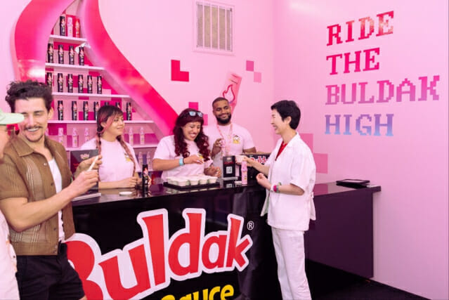 김정수 부회장이 불닭소스 부스에서 시식하는 모습.