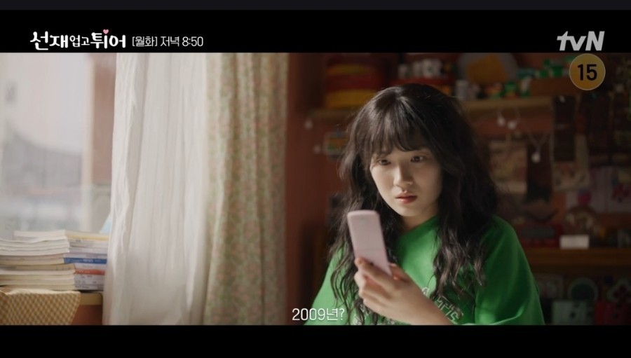 선재 업고 튀어 드라마의 한장면 여자 주인공이 핸드폰을 보고 시간을 알아보고 있다.