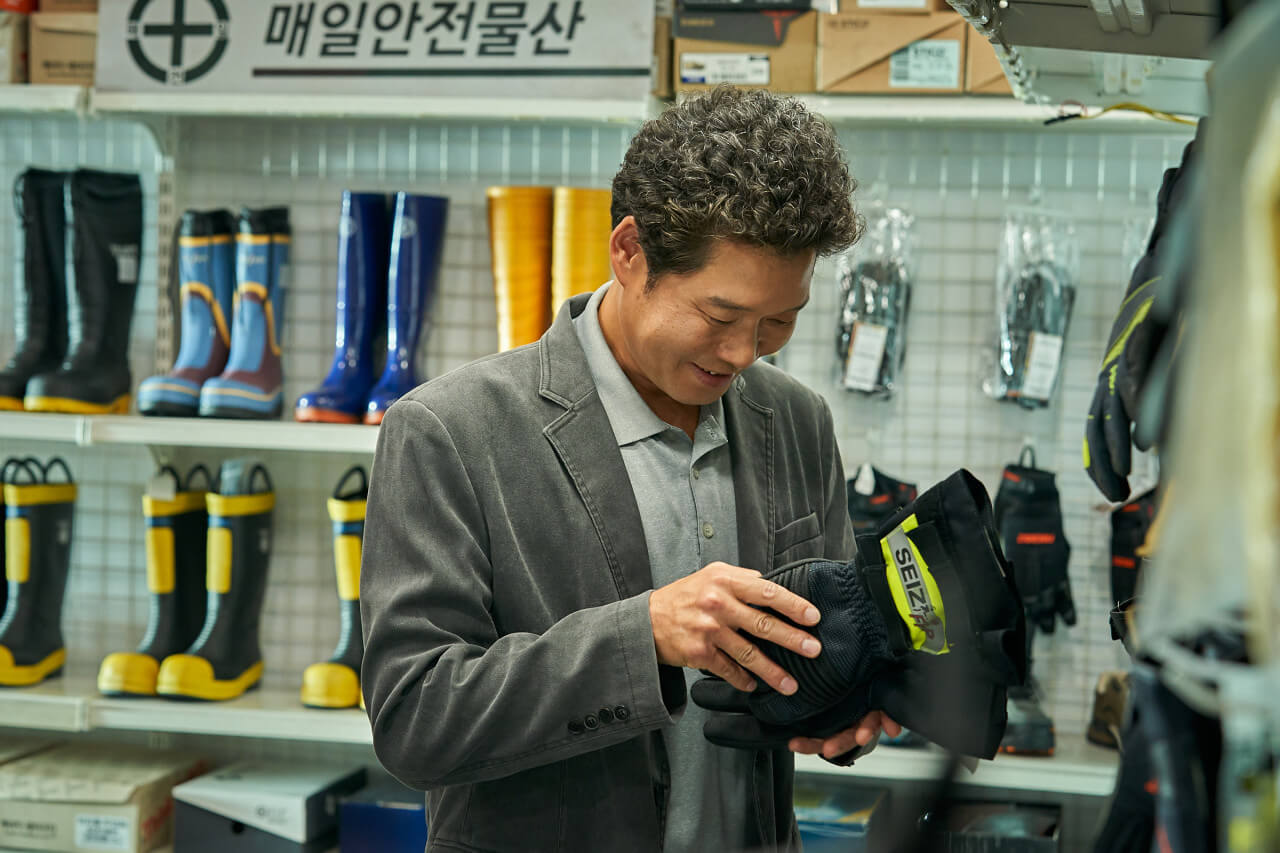 구조대장 강인기가 사비로 요원들에게 줄 방화 장갑을 고르며 웃고 있는 모습