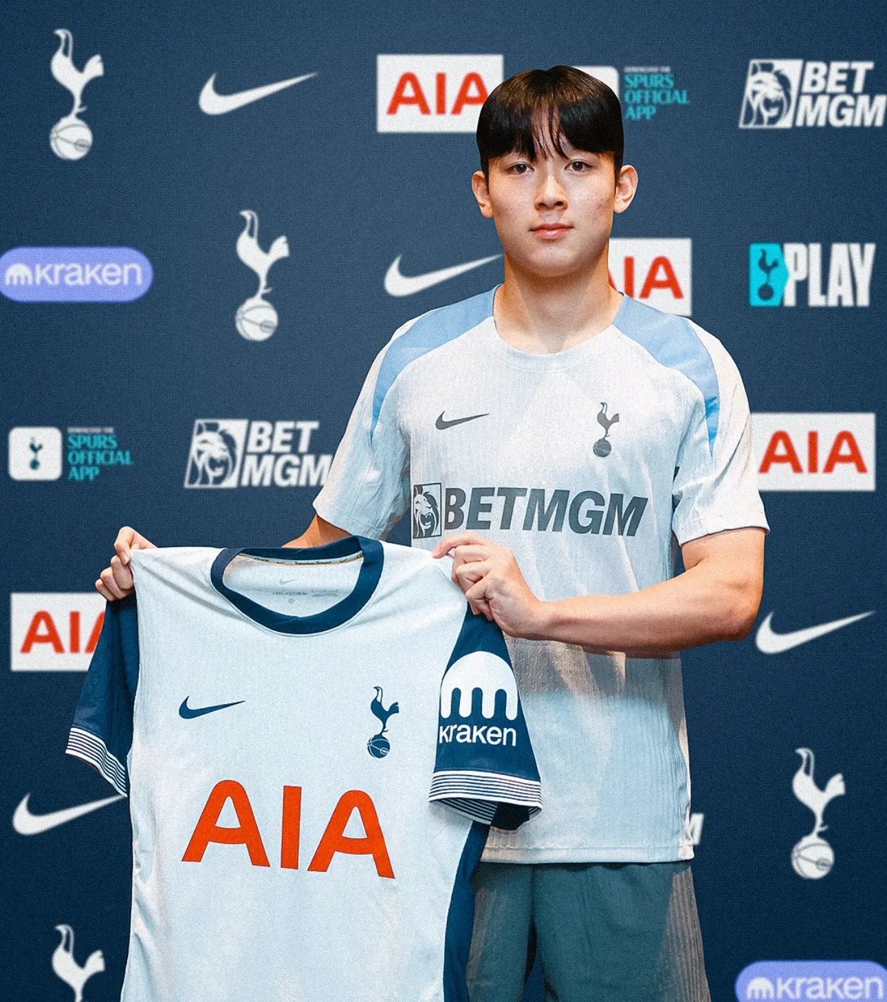양민혁이 토트넘 유니폼을 들고 공식 포토월 앞에서 입단 기념 촬영을 하는 모습,