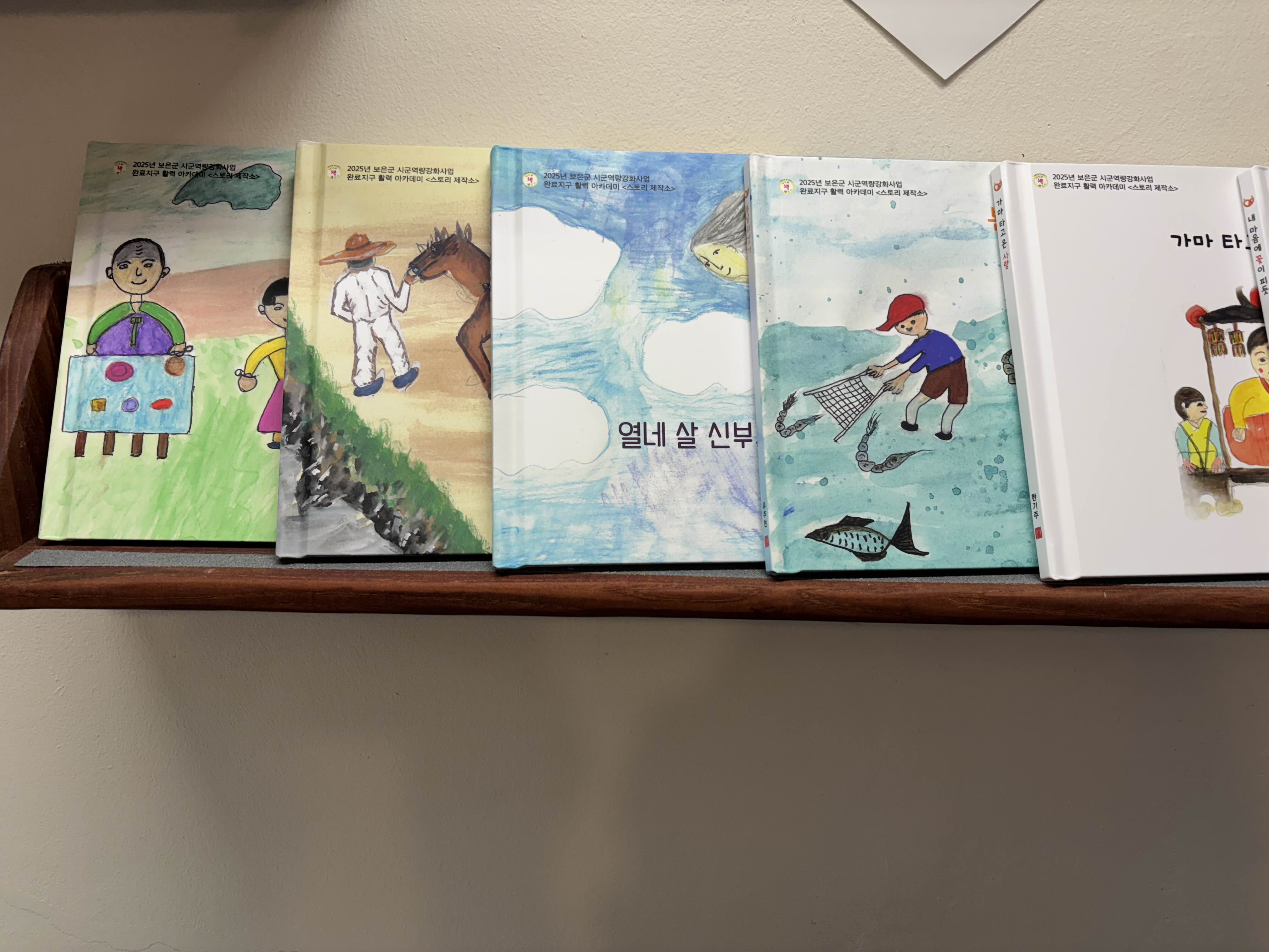 어르신 그림책 만들기 프로그램에서 완성한 자서전 그림책. 삶의 기억과 가족 이야기를 담은 그림책 작품 전시 모습.