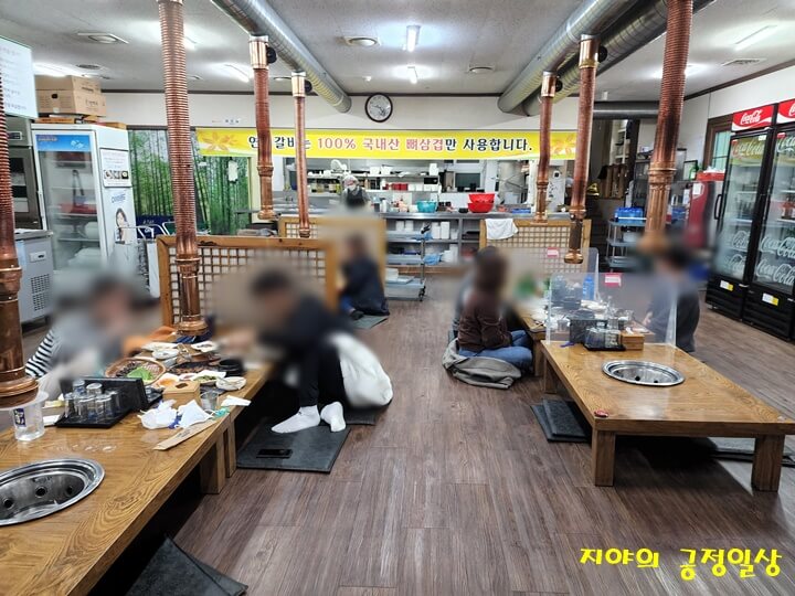 홀에서 좌식 테이블에서 식사하는 사람들