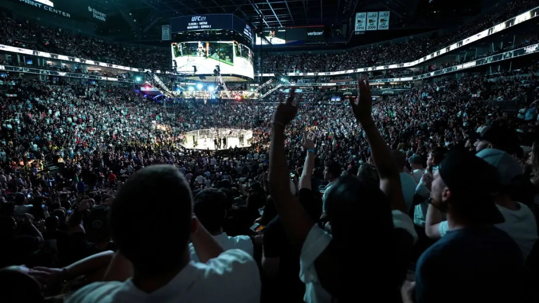 팬들이 UFC 경기를 열광적으로 관람하는 모습