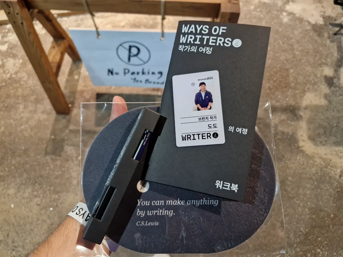 팝업스토어-굿즈상품을-들고있는-모습-펜-작가카드-워크북-마우스패드