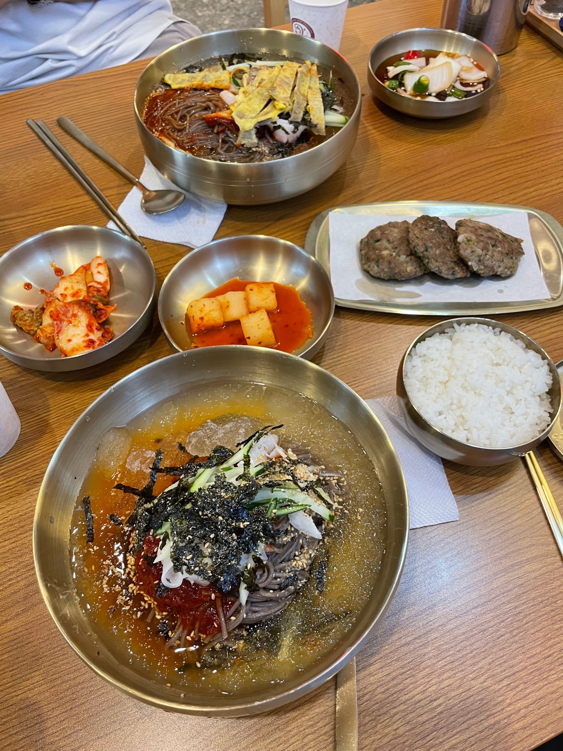 Makguksu with side dishes and meat patties at Yukjeon Gukbap Sinseol-dong.