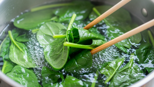 끓는 소금물에 시금치를 넣고 젓가락으로 살짝 뒤적인 후 바로 건져내고 있는 모습