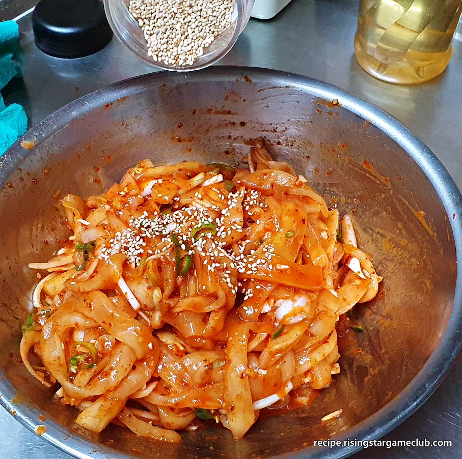 야채와 함께 잘 버물러진 노각 무침에 통깨를 뿌려주는 사진