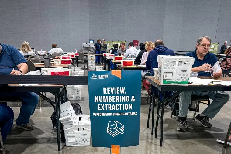 미국 대선 투표 개표 현장에서 양당 팀이 투표지를 검토, 번호 지정 및 추출 작업을 수행하는 모습