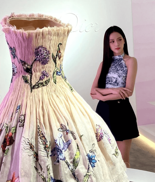 지수가 디올 드레스 앞에서 사진 찍는 장면